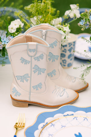 Baby blue cowgirl boots by Wild & Rae featuring decorative bows and classic Western style for girls.