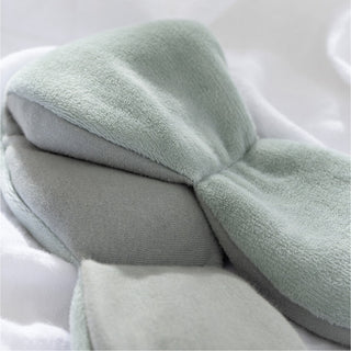 Noppod Weighted Sleep Eye Mask - Sage
Stack of light green towels on a white surface
