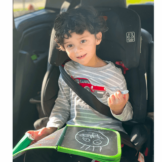 Daily Doodler Reusable Activity Book - Games on the Go
Child sitting in a car seat with a coloring book and crayon