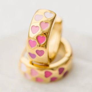 Pierced Co. Chunky Pink Heart Ombré Huggies
Gold ring with pink heart patterns on a light background
