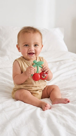 Itzy Ritzy Bitzy Shake silicone teether with cherry pattern and rattle, designed for soothing and entertaining babies.