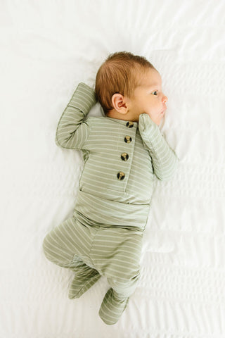 Lou Lou and Company Knit Top and Bottoms - Carson
Baby wearing a green striped onesie lying on a white surface