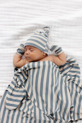 Lou Lou and Company Ribbed Swaddle Blanket - Lincoln
Newborn baby wrapped in a blue and white striped blanket and hat on a white background