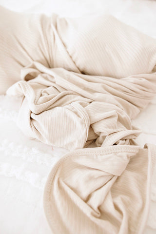 Lou Lou and Company Ribbed Swaddle Blanket - Cove
Beige textured fabric on a white background
