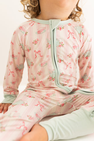In My Jammers Zipper Romper - Tea Party
Child wearing a pink and gray patterned outfit with a white background