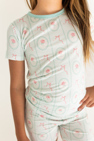 In My Jammers Two Piece Short Set - Eloise
Person wearing a light green pajama set with pink and red patterns on a plain background