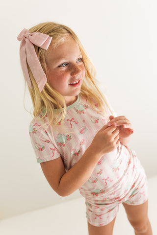 In My Jammers Two Piece Short Set - Tea Party
Young girl wearing a pink floral outfit with a matching headband on a white background