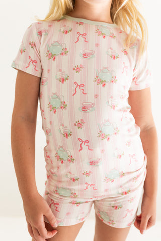 In My Jammers Two Piece Short Set - Tea Party
Child wearing a pink pajama set with tea cup and bow pattern on a plain background