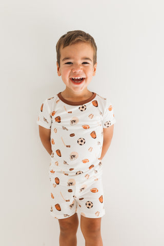 In My Jammers Two Piece Short Set - Sports
Child wearing a white romper with colorful patterns on a plain background