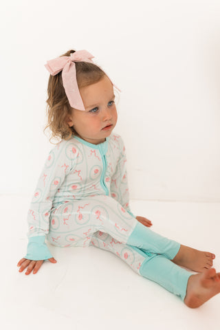 In My Jammers Zipper Romper - Eloise
Child wearing a light blue and white outfit with a pink bow on a white background