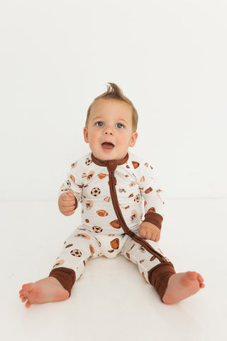In My Jammers Zipper Romper - Sports
Baby wearing a patterned onesie with brown accents on a white background
