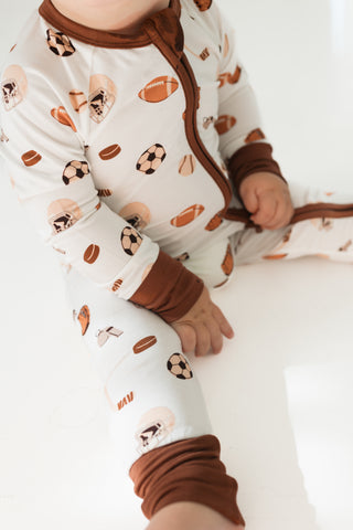 In My Jammers Zipper Romper - Sports
Baby wearing a onesie with sports-themed print on a white background