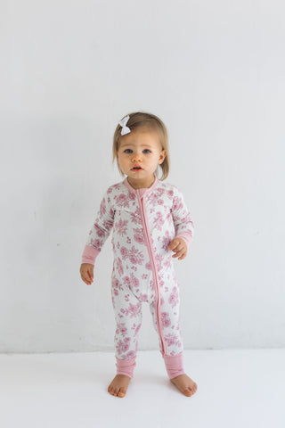 In My Jammers Blush Garden Zipper Romper
Child wearing a pink floral onesie on a white background