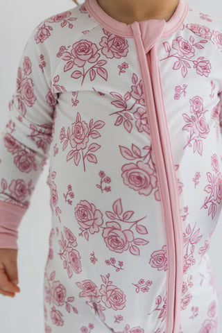 In My Jammers Blush Garden Zipper Romper
Baby onesie with pink floral pattern on a white background