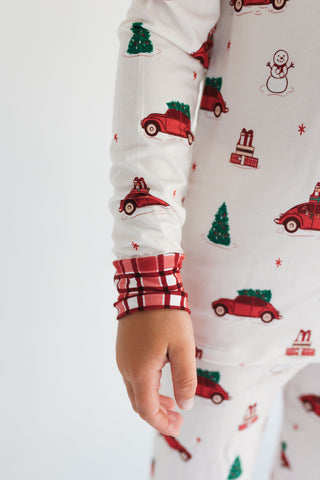 In My Jammers Red Holly Jolly Cruisers Two Piece Set
Close-up of a hand wearing a Christmas-themed pajama sleeve with red plaid cuffs.