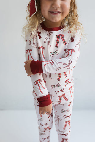 In My Jammers Merry Little Bows Two Piece Set
Child wearing a pajama set with candy cane and bow pattern on a plain background