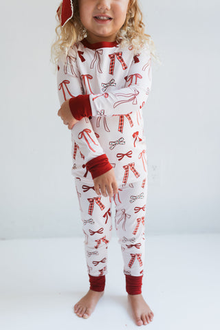 In My Jammers Merry Little Bows Two Piece Set
Child wearing a white onesie with red patterns on a plain background