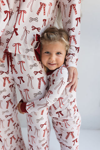 In My Jammers Merry Little Bows Women’s Set
Child wearing pajamas with red bows on a white background