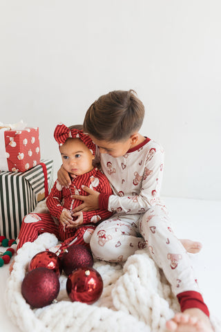 In My Jammers Bear-y Merry Two Piece Set
Two children in matching pajamas with red ornaments and a white blanket.