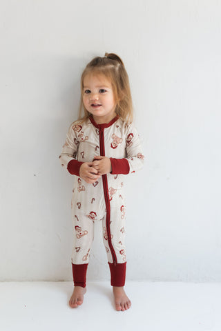 In My Jammers Bear-y Merry Zipper Romper
Child wearing a patterned onesie with red accents on a white background