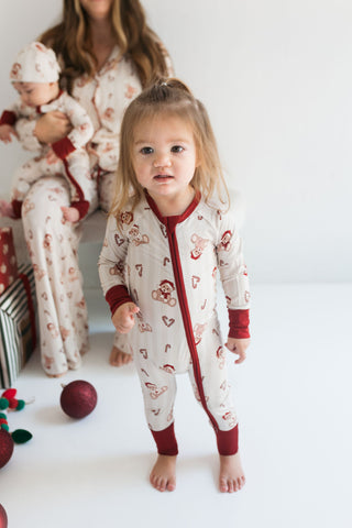 In My Jammers Bear-y Merry Zipper RomperChild wearing a patterned onesie with a family in the background