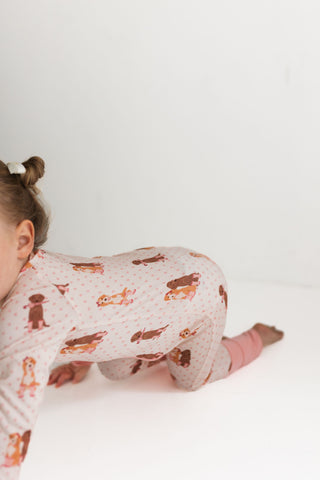 In My Jammers Zipper Romper - Pink Pup Friends
Child wearing pajamas with animal print on a white background