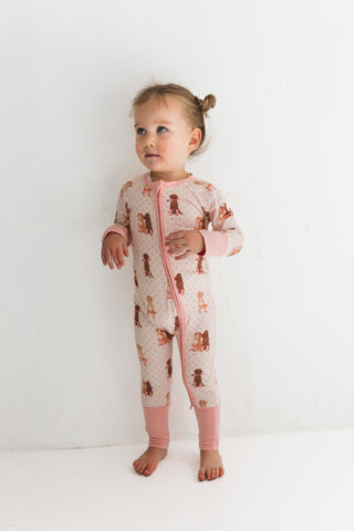 In My Jammers Zipper Romper - Pink Pup Friends
Child wearing a patterned onesie with pink accents on a white background