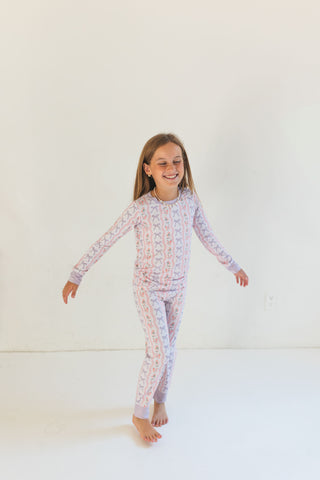 In My Jammers Two Piece Set - Purple Amelia Bow
Child wearing a patterned pajama set on a white background