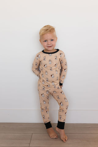 In My Jammers DJ BooMBox Two Piece Set Child wearing a beige pajama set with animal print against a white wall.