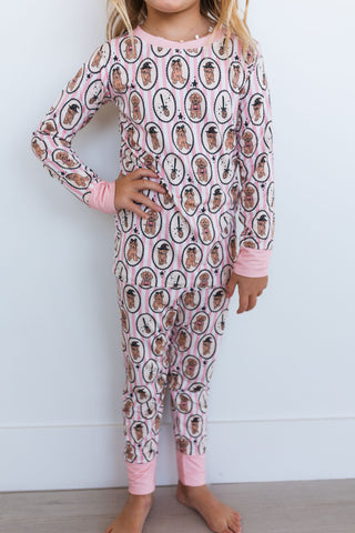 In My Jammers Howl-O-Ween Pups Two Piece Set Child wearing a pink pajama set with printed design against a white background