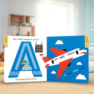 D is for Dump Truck Lift The Flap Board Book
Children's book with airplane illustration on a wooden surface