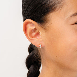 Pip Pop Post Earrings - Opal Dual Stud
Close-up of an ear wearing a small round earring with a plain background