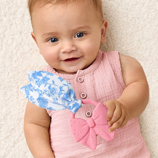 Itzy Ritzy Crinkle Crew™ bow teether for babies, featuring soft fabric and crinkle sound, designed for teething relief and sensory play.