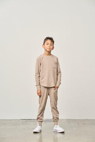 Little Bipsy Waffle Jogger - Mushroom
Child wearing a beige sweatshirt and pants set against a plain background