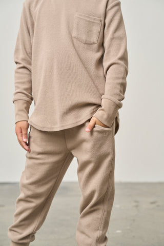 Little Bipsy Waffle Jogger - Mushroom
Person wearing a beige long-sleeve shirt and pants against a plain background