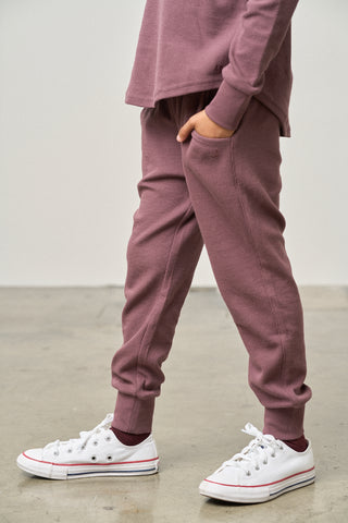 Little Bipsy Waffle Jogger - Huckleberry
Person wearing mauve sweatpants and white sneakers on a plain background