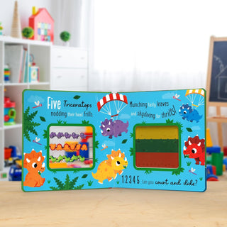 Count and Slide Dinosaurs Board Book
Children's educational board book with colorful illustrations on a wooden surface.