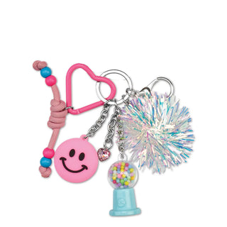 Iscream Gumball Machine Bag Charm
A pink and silver keychain set featuring a pink heart-shaped carabiner, a pink smiley face charm, a pink braided cord with blue and pink beads, a light blue gumball machine charm filled with colorful candies, and a large iridescent silver tinsel pom-pom.