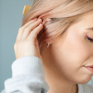 Pip Pop Post "Diamond" Gold Hoops
Woman with blonde hair touching her ear, wearing a gold earring.