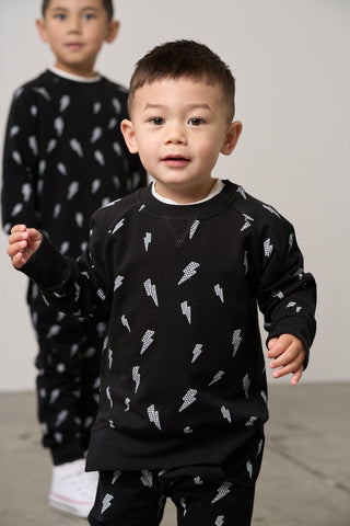 Little Bipsy Lightning Bolt Pullover - Black
Little Bipsy Lightning Bolt Jogger - Black
Two children wearing black pajamas with white patterns on a plain background