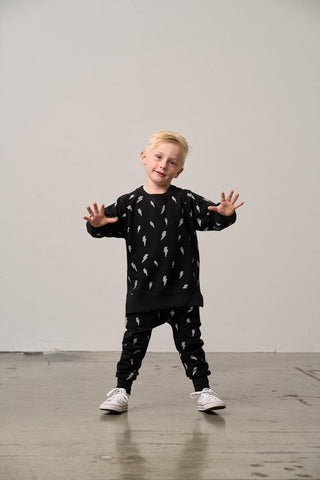 Little Bipsy Lightning Bolt Pullover - Black
Child wearing a black outfit with white patterns on a plain background