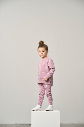 Little Bipsy Smiley Jogger - Dusty Purple
Child wearing a pink outfit with floral patterns on a plain background