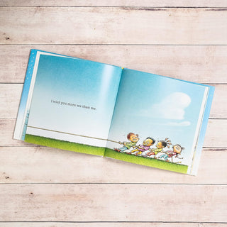 I Wish You More Hardcover Book
Open book with cartoon children on a wooden surface