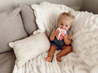 Itzy Ritzy Bow Teensy Crinkle™ teether with colorful crinkle fabric and bow design for babies' teething comfort.