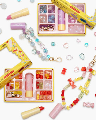 Super Smalls Cutie Candy Lip Balm Bead Kit
Colorful children's toys and accessories including lip balms, beads, and a small camera on a white background.