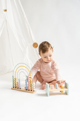Kalencom Rainbow Abacus
Baby playing with a wooden toy set on a white background