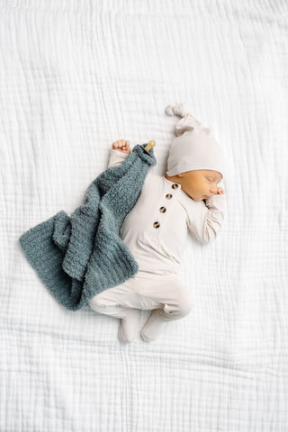 Lou Lou and Company Top and Bottoms - Winnie
Newborn baby in a snowman outfit lying on a white textured surface