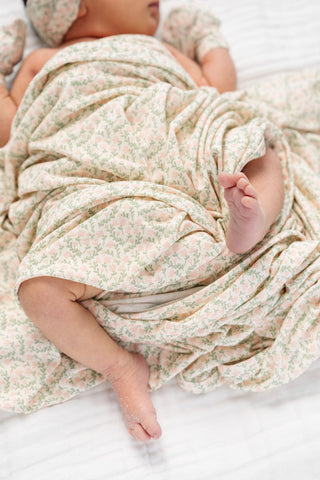 Soft Lou Lou and Company Quincy swaddle blanket with pastel floral pattern, ideal for wrapping and soothing babies.