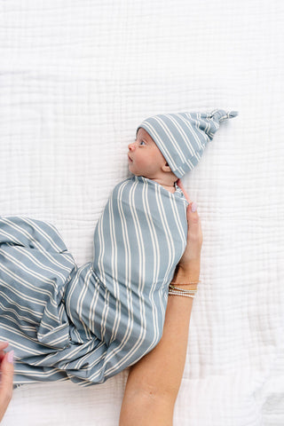 Lou Lou and Company Swaddle Blanket - Wells
Baby swaddled in a striped blanket and cap on a white textured surface