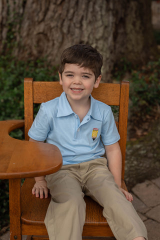 City Beautiful Pencil Polo
Young boy sitting on a wooden chair outdoors with a tree in the background